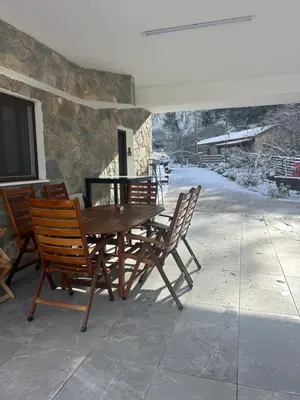 a wooden table and chairs on a patio at DIAMOND Stone Wooden Guest House in Khandria