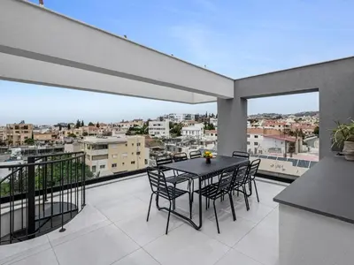 a patio with a table and chairs on a balcony at Sanders Elgio in Limassol