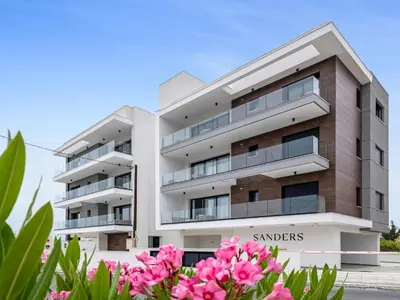 a building with pink flowers in front of it at Sanders Elgio in Limassol