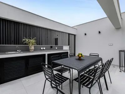 a dining room with a black table and chairs at Sanders Elgio in Limassol