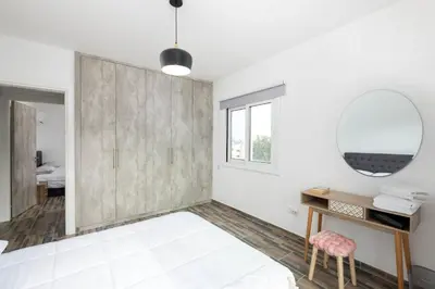 a bedroom with white walls and a mirror and a bed at Happy Stay Apartment - Halefka Court in Larnaka