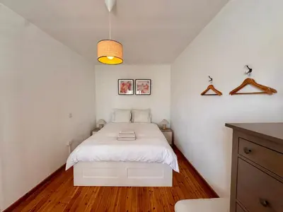 a bedroom with a white bed with a wooden floor at Liberty House - Central Two Bedroom Apartments in Nicosia