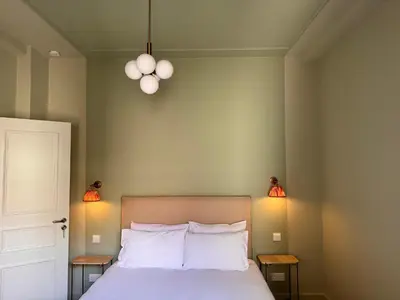 a bedroom with a bed with two lights on the wall at Liberty House - Central Two Bedroom Apartments in Nicosia