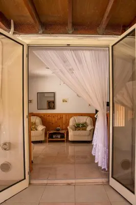 a room with glass doors and a living room with a couch at Spyros No23 Charming Oceanview Maisonette in Meneou