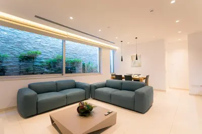 a living room with two blue couches and a table at Cove Seaview Villas - Neptune in Ayia Napa