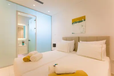a bedroom with a large white bed with towels on it at Cove Seaview Villas - Neptune in Ayia Napa