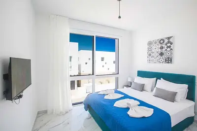 a bedroom with a blue bed with two towels on it at Vie Bleu 1 in Protaras