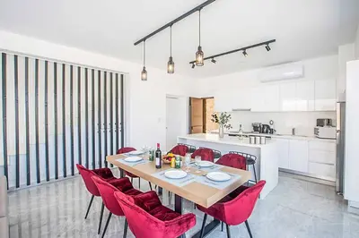 a dining room with a table and red chairs at Vie Bleu 3 in Protaras