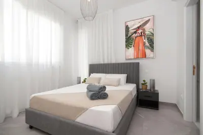 a white bedroom with a bed with a stuffed animal on it at Queen Lydia in Protaras