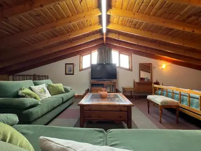 a living room with a couch and a tv at Kapilio Cottage House in Kapilio