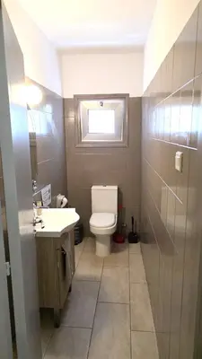a bathroom with a toilet and a sink and a window at Comfy and Exquisite ROOMS in a Shared 3BR Apartment Near Main Harbor, City Center in Larnaka