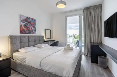 a bedroom with a large bed and a large window at Sunshine 1-Bedroom Apartment in Larnaca in Larnaka