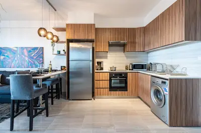 a kitchen with stainless steel appliances and a dining room at Sunshine 1-Bedroom Apartment in Larnaca in Larnaka