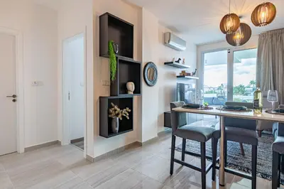 a living room with a table and chairs and a window at Sunshine 1-Bedroom Apartment in Larnaca in Larnaka