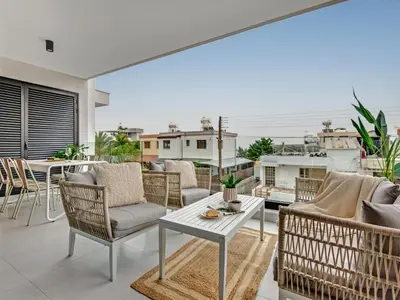 a living room with chairs and a table on a balcony at Sanders Only in Limassol
