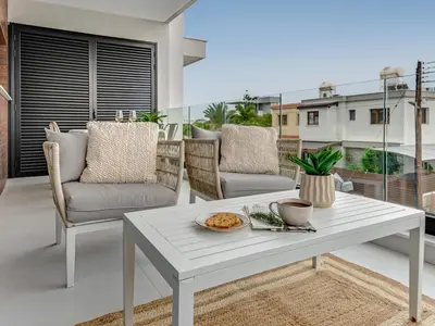 a white coffee table and chairs on a balcony at Sanders Only in Limassol
