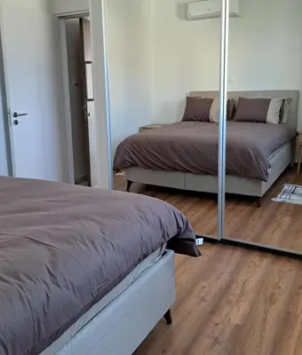 a bedroom with two beds and a mirror at ICEBUILD APARTMENTS in Nicosia