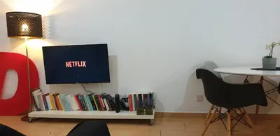 a tv sitting on top of a shelf with books at LINA'S HOME & POOL - Breakbooking CY in Laxia
