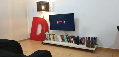a tv sitting on top of a shelf with books at LINA'S HOME & POOL - Breakbooking CY in Laxia
