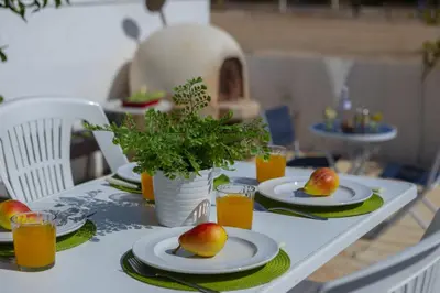 a table with plates of fruit and glasses of orange juice at Melis Villa - Charming villa in Central Protaras in Protaras
