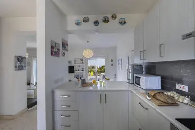 a kitchen with white cabinets and a microwave at Melis Villa - Charming villa in Central Protaras in Protaras