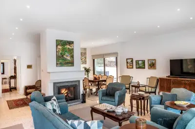 a living room with blue chairs and a fireplace at Platres Forty Pine Trees Cottage in Platres