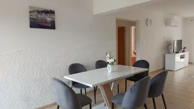 a dining room with a white table and blue chairs at NISSI GOLDEN SANDS SEA VIEW 2 BEDROOM Apartment in Ayia Napa