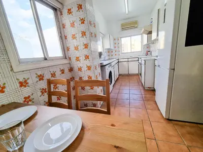a kitchen with a wooden table and a white refrigerator at City View Rooms in Larnaka