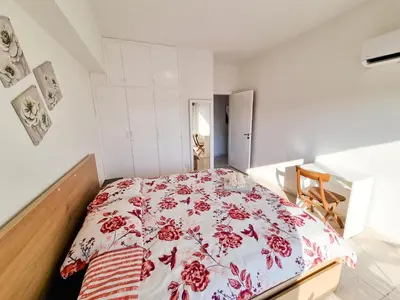 a bedroom with a bed with a red and white blanket at City View Rooms in Larnaka