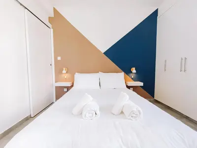 a bedroom with a white bed with towels on it at Shelter next to the beach in Larnaka