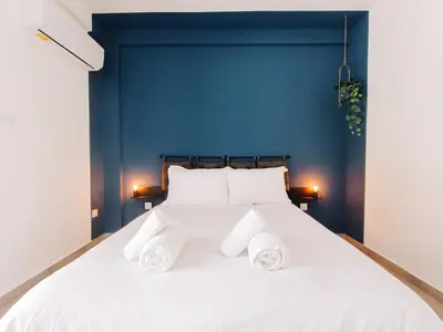 a white bed with two rolled towels on it at Shelter next to the beach in Larnaka