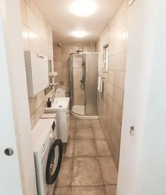 a bathroom with a shower and a washing machine at Shelter next to the beach in Larnaka