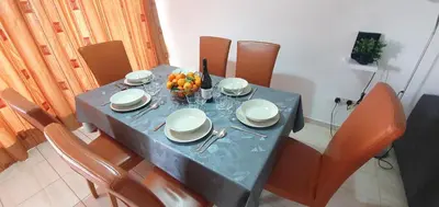 a table with plates and bowls of fruit on it at Vasilas Holiday Apartment #2 in Larnaka