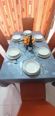 a blue table with plates and glasses and a bottle of wine at Vasilas Holiday Apartment #2 in Larnaka