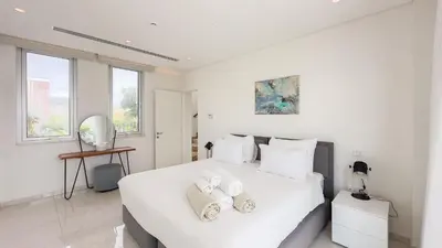 a white bedroom with a large white bed with two pillows at Vivo Mare Beachfront Villas - Vista in Ayia Napa