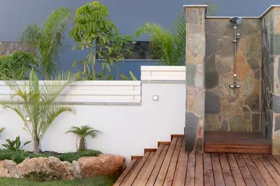 a bathroom with a shower and a wooden deck at Sea Pearl Beachfront Villas - Breeze in Ayia Napa