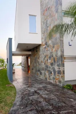 a stone walkway next to a building with a stone wall at Sea Pearl Beachfront Villas - Anemone in Ayia Napa