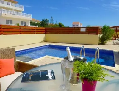 a table with a sink and a swimming pool at Nissi Beach Golden Villas in Ayia Napa