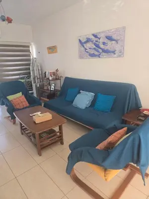 a living room with a blue couch and a table at Lazuli Seafront Beach House Nr18 in Larnaka