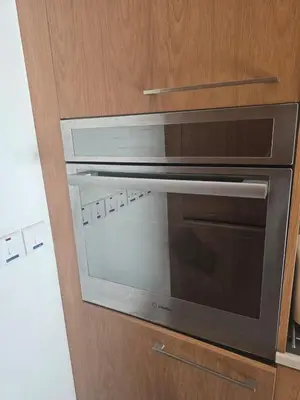 a microwave oven sitting inside of a wooden cabinet at Lazuli Seafront Beach House Nr18 in Larnaka