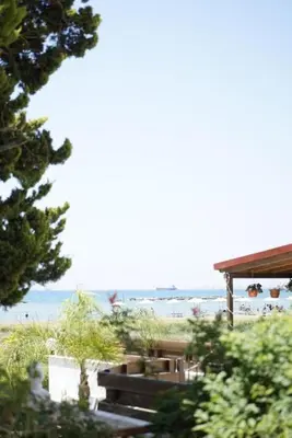 a beach with a pavilion and the ocean in the background at Lazuli Seafront Beach House Nr18 in Larnaka