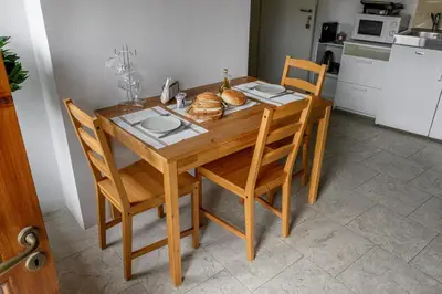 a wooden table with chairs and a plate of food on it at Omodos vintage houses in Omodos