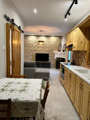 a kitchen and living room with a table and a couch at Eftis - Renovated Traditional House in Omodos