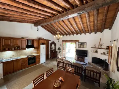 a kitchen and living room with wooden ceilings and a table at King's house in Lofou
