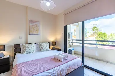 a bedroom with a bed and a large window at Freya 1-Bedroom Apartment in Larnaca in Larnaka