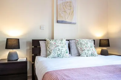 a bedroom with a bed with pillows and two lamps at Freya 1-Bedroom Apartment in Larnaca in Larnaka