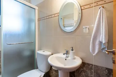 a bathroom with a toilet and a sink and a mirror at Freya 1-Bedroom Apartment in Larnaca in Larnaka