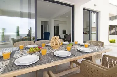 a table with plates of food and drinks on it at Villa Amity in Protaras