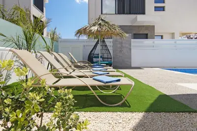 a group of lounge chairs sitting next to a pool at Villa Talia in Protaras