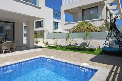 a house with a swimming pool next to a building at Villa Talia in Protaras